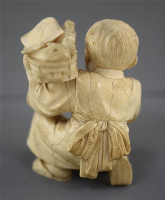 A Japanese ivory okimono of a boy with a dog, Meiji period, height 7.5cm excl. wood stand